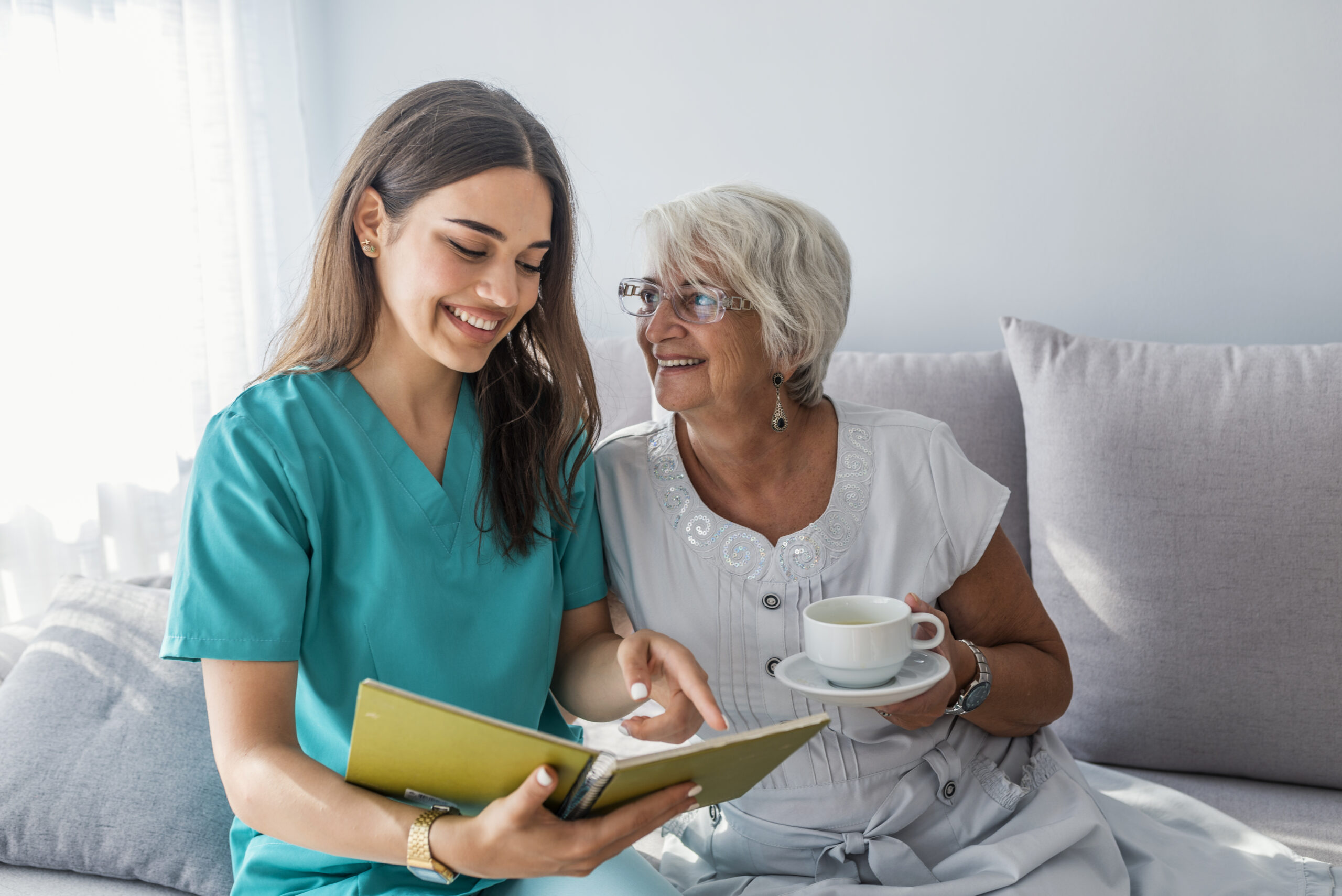 Happy patient is holding caregiver for a hand while spending tim